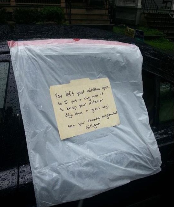 You left your window open, so I put a bag over it to keep your interior dry. Have a great day! from you friendly neighborhood Gilligan. Written on a manila folder taped to a trash bag covering a window of a black car. 