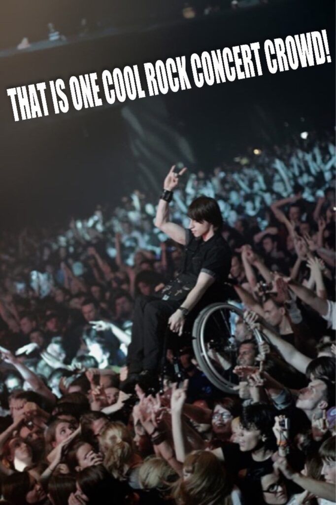 That is one cool rock concert crowd! At a concert, crowd is crowd surfing a man in a wheelchair. 